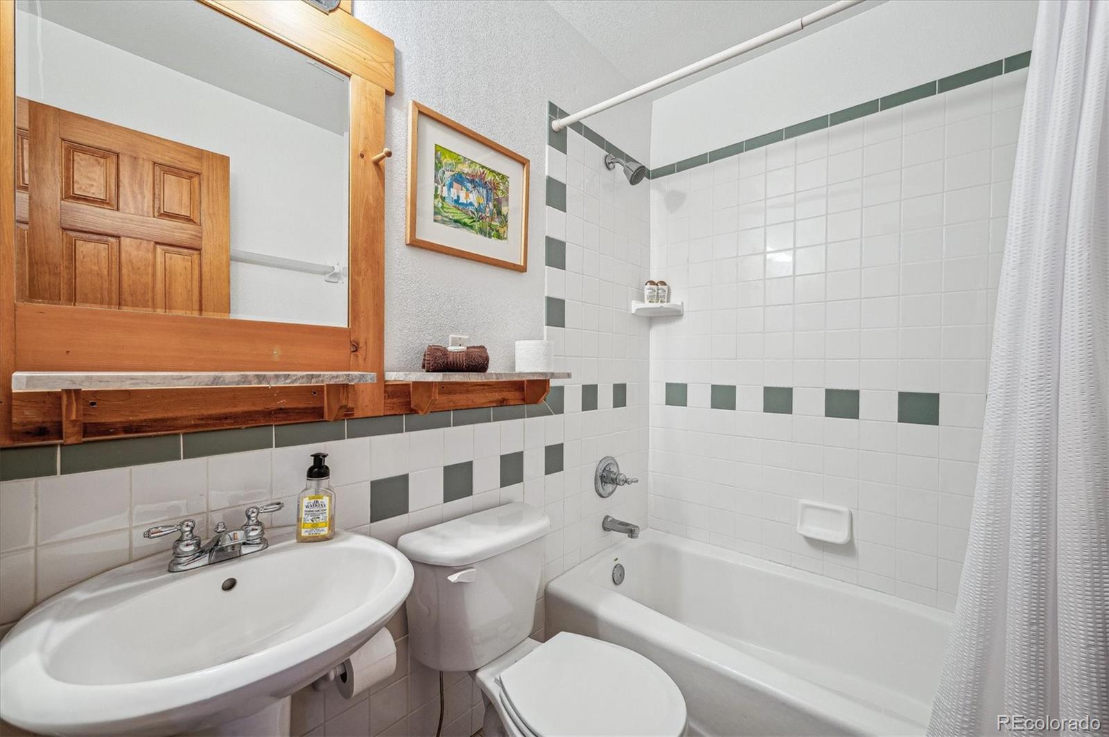 12973 Upper Ridge Road Conifer, CO 80433 - Photo 21 of 46 a bathroom with a bathtub shower sink mirror and toilet