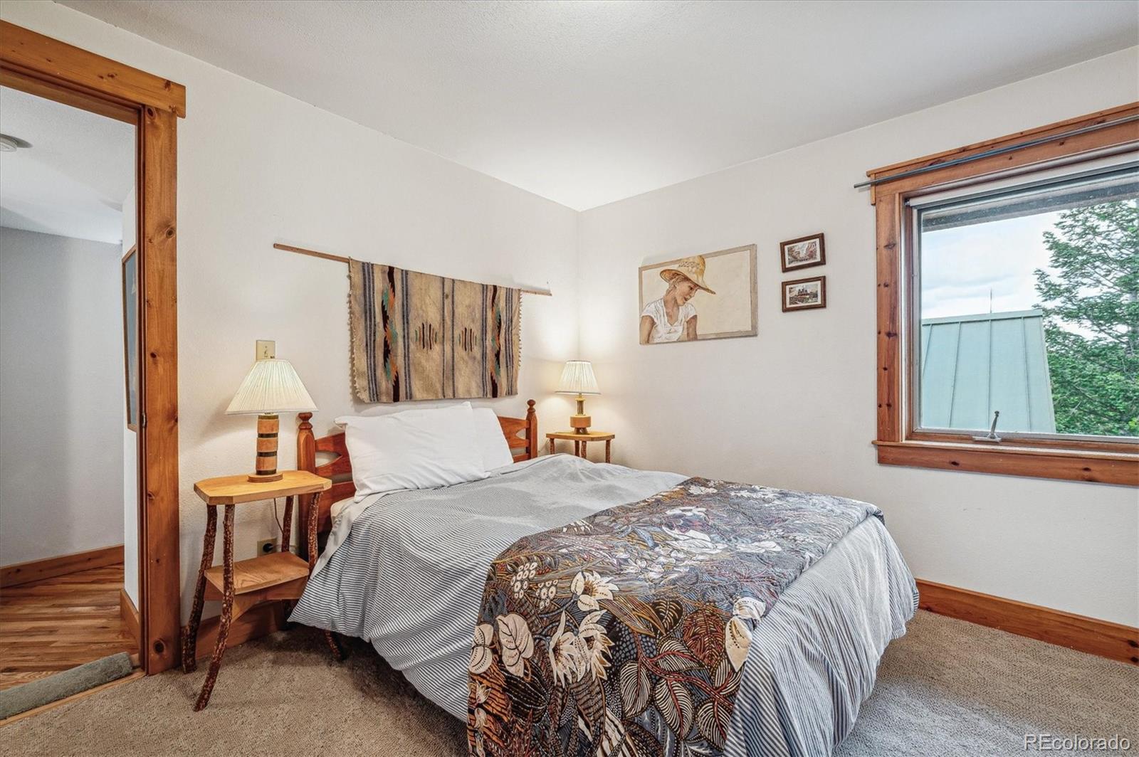 12973 Upper Ridge Road Conifer, CO 80433 - Photo 23 of 46 a bedroom with a bed and a window