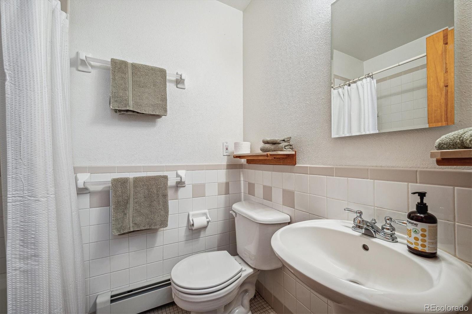 12973 Upper Ridge Road Conifer, CO 80433 - Photo 24 of 46 a bathroom with a toilet sink and mirror