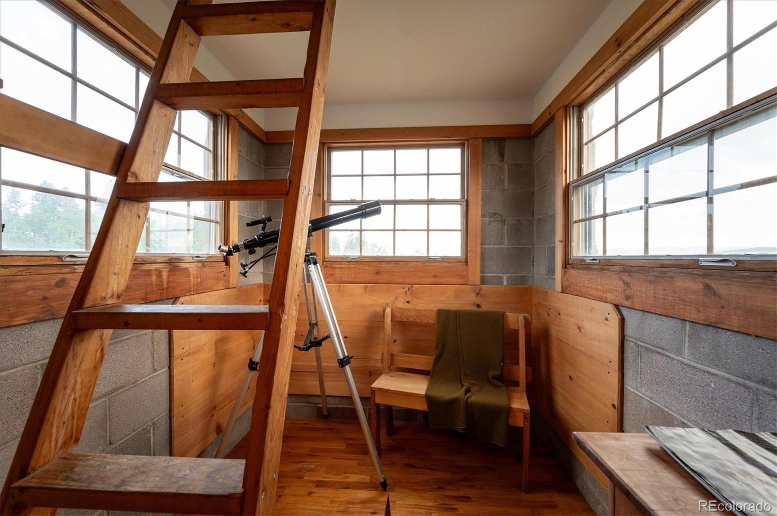 12973 Upper Ridge Road Conifer, CO 80433 - Photo 25 of 46 a view of a room with wooden floor and furniture