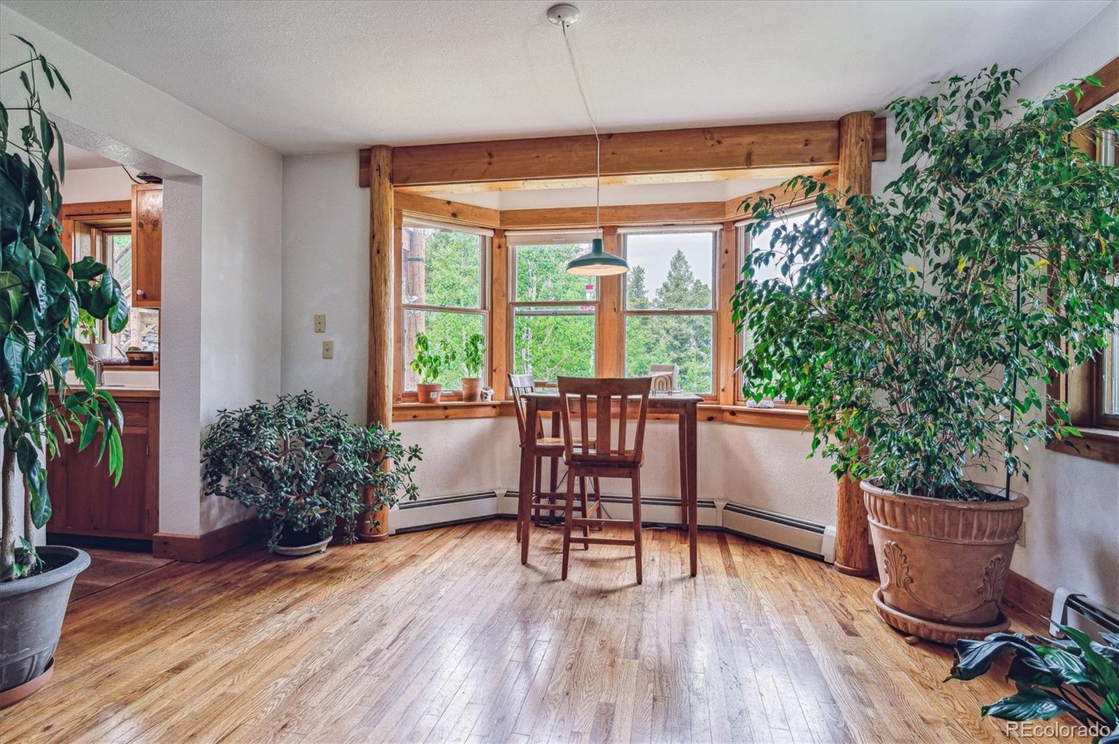 12973 Upper Ridge Road Conifer, CO 80433 - Photo 30 of 46 a dining room with furniture window and wooden floor