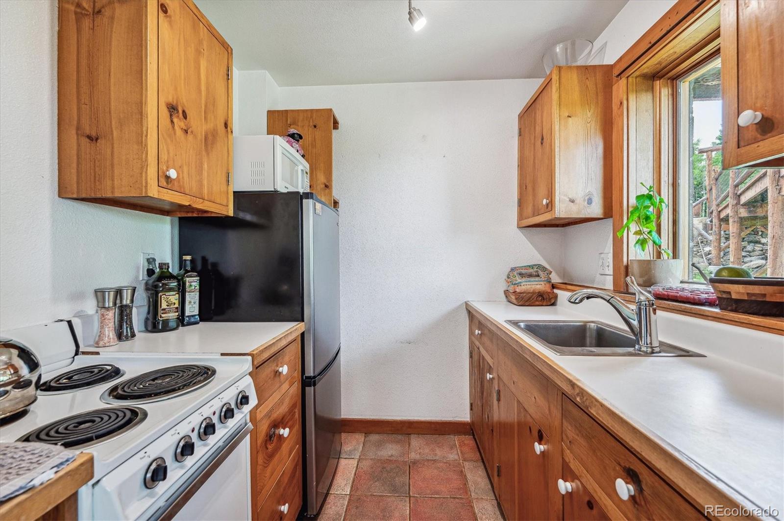 12973 Upper Ridge Road Conifer, CO 80433 - Photo 32 of 46 a kitchen that has a sink and a stove