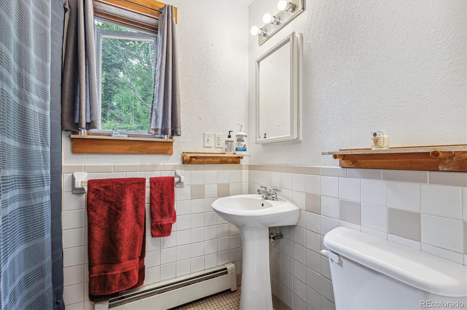 12973 Upper Ridge Road Conifer, CO 80433 - Photo 33 of 46 a bathroom with a sink toilet and mirror