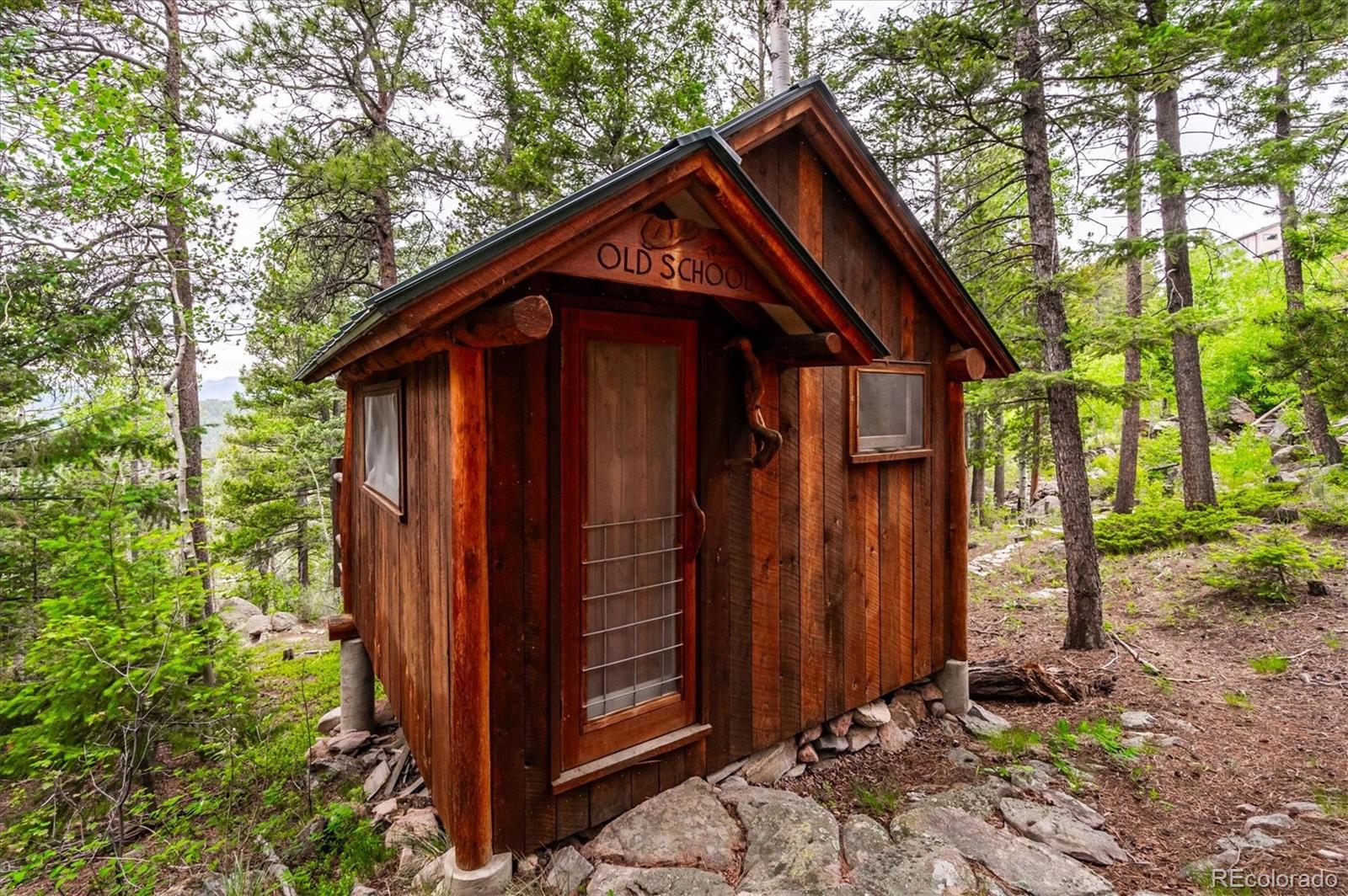 12973 Upper Ridge Road Conifer, CO 80433 - Photo 35 of 46 a front view of a house with garden