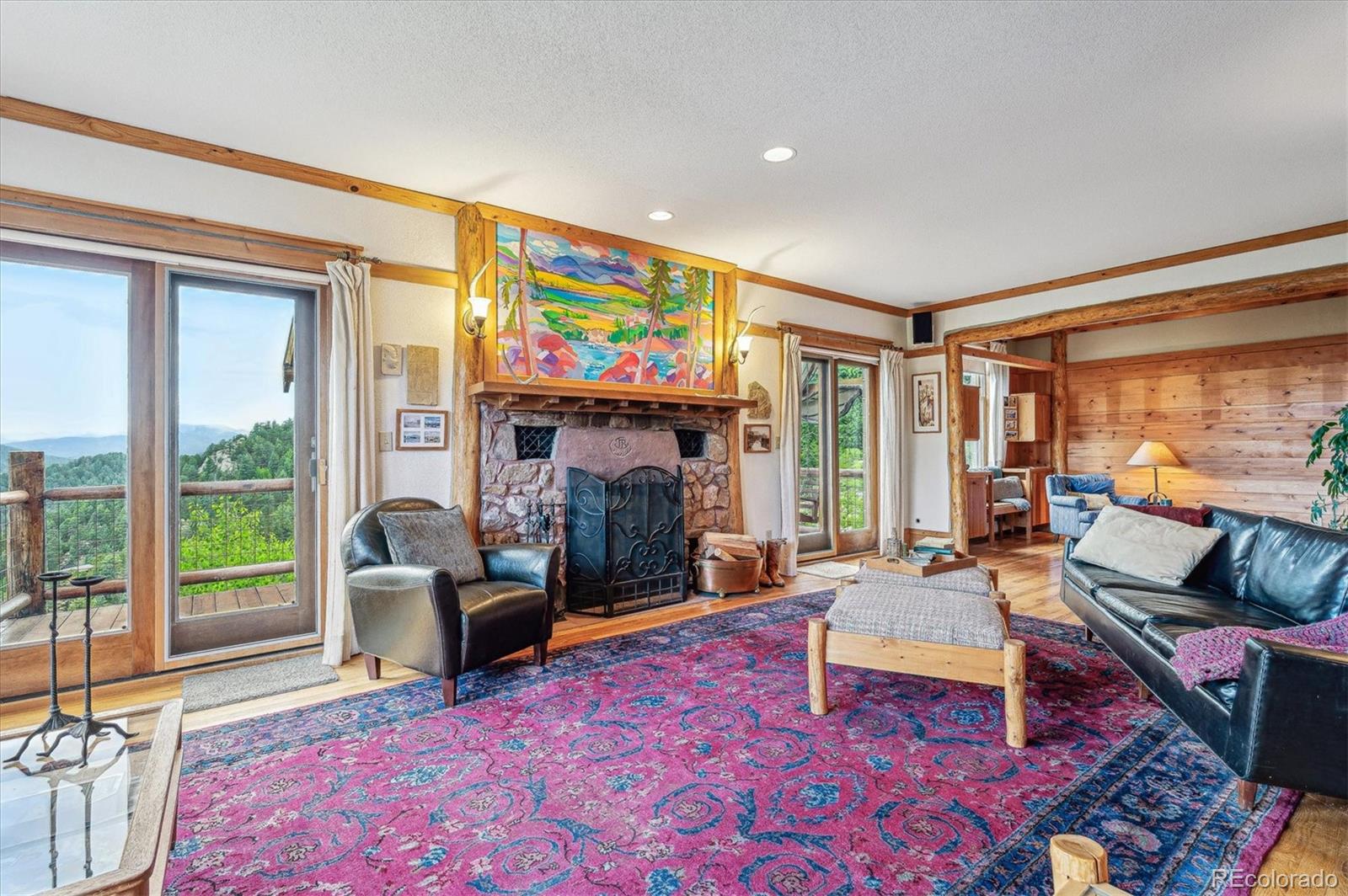 12973 Upper Ridge Road Conifer, CO 80433 - Photo 4 of 46 a living room with furniture a rug and a fireplace
