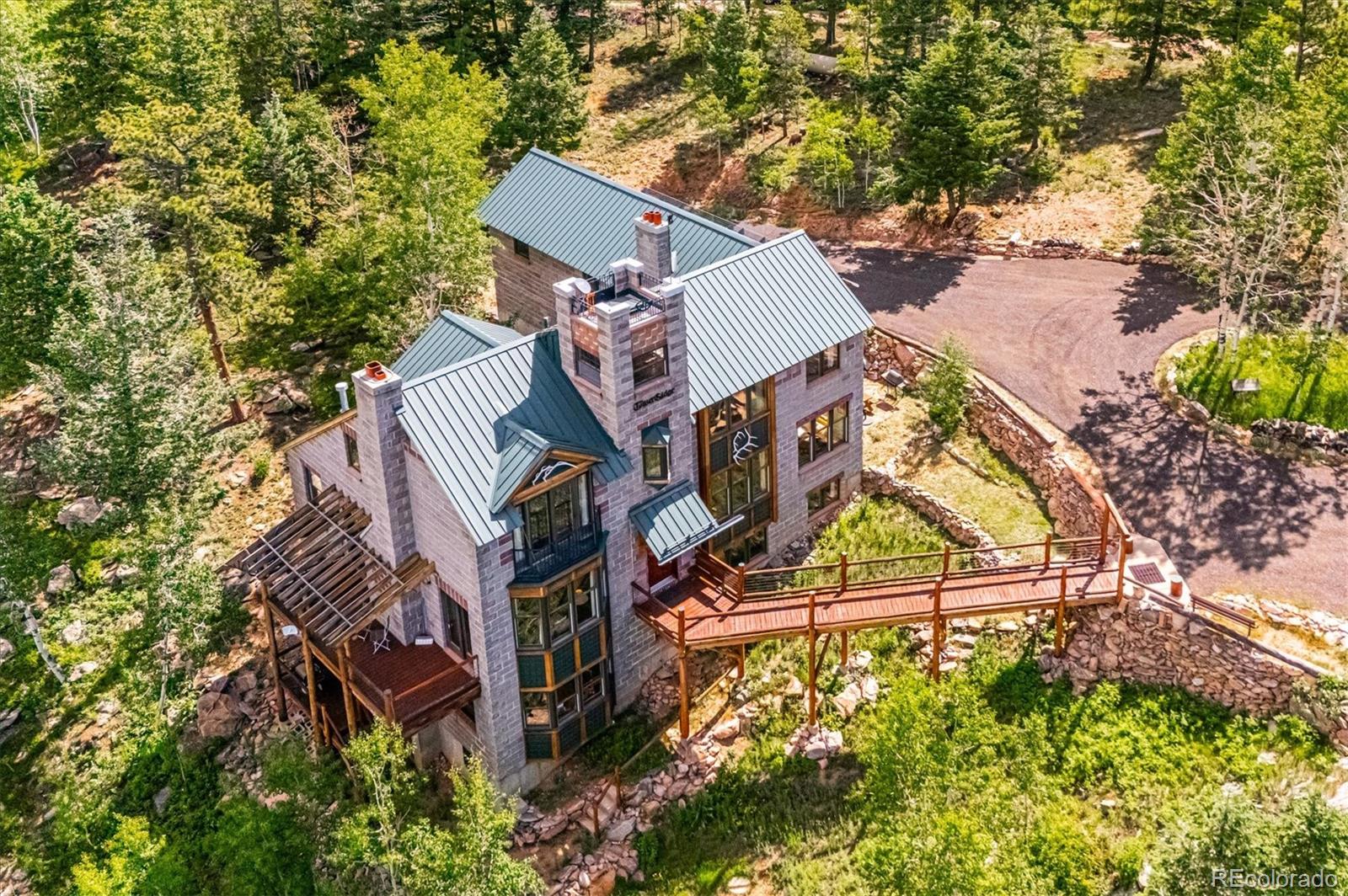 12973 Upper Ridge Road Conifer, CO 80433 - Photo 41 of 46 an aerial view of a house with swimming pool and garden