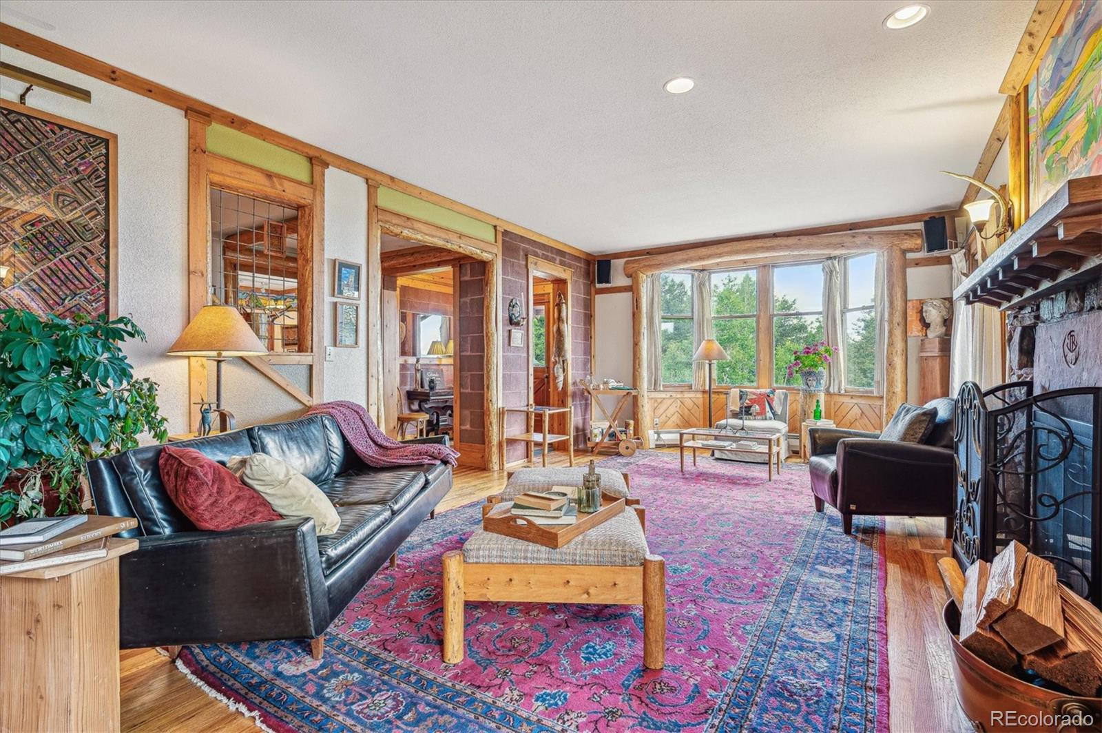 12973 Upper Ridge Road Conifer, CO 80433 - Photo 5 of 46 a living room with furniture fireplace and a large window