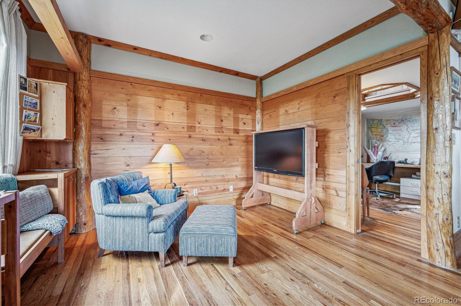 12973 Upper Ridge Road Conifer, CO 80433 - Photo 6 of 46 a living room with furniture and a flat screen tv