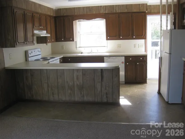 a kitchen with stainless steel appliances a sink a stove a refrigerator and cabinets