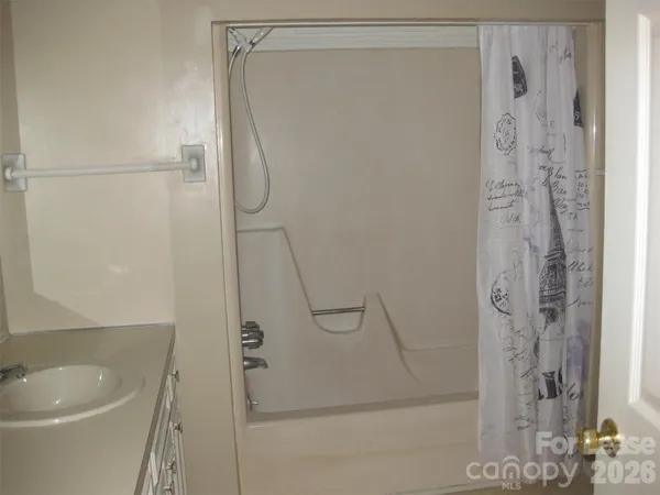 a bathroom with a granite countertop shower and a sink