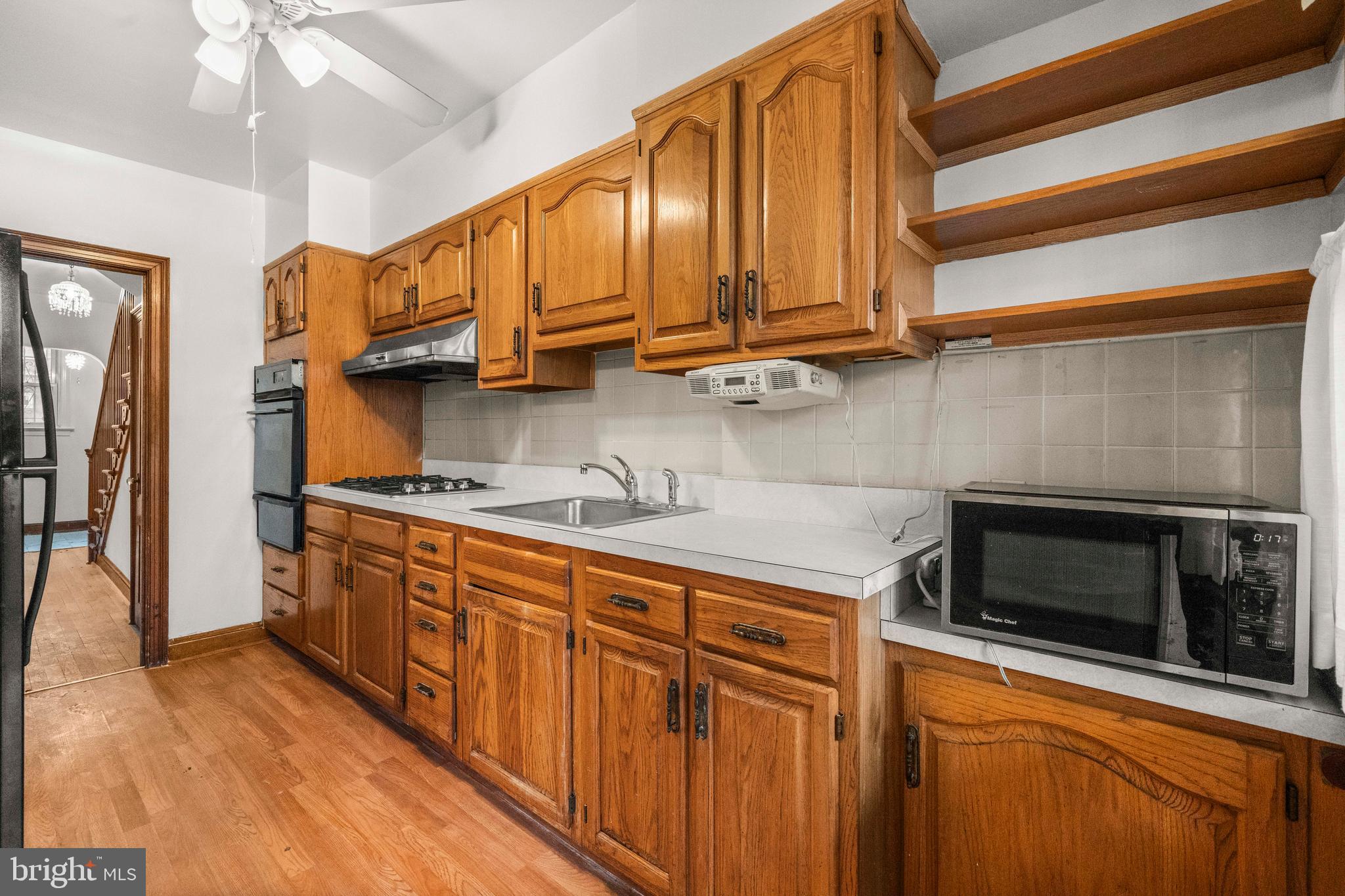 4108 Grant Street Northeast Washington, DC 20019 - Photo 14 of 31 a kitchen with stainless steel appliances granite countertop a sink a stove cabinets and wooden floor