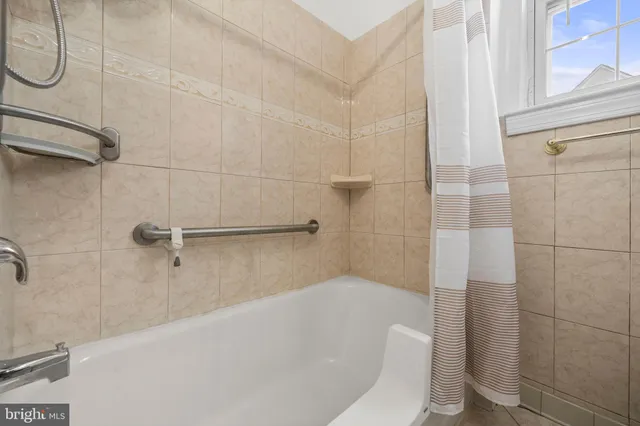 a bathroom with a white bath tub and shower