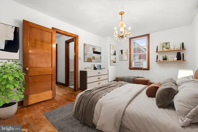 a bedroom with a balcony a bed and a chandelier