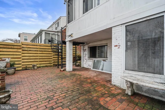 a view of a house with a barbeque and wooden stairs