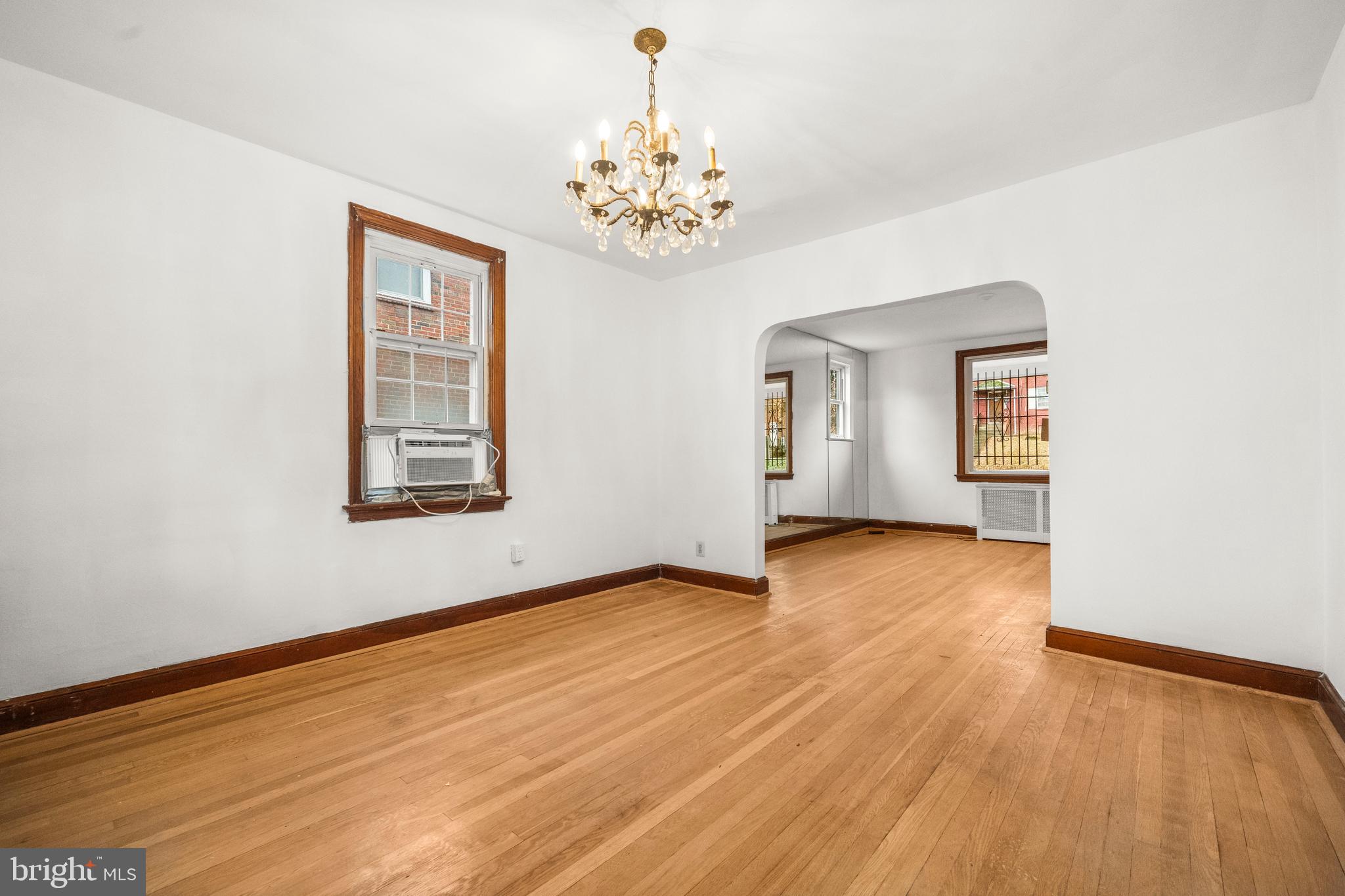 4108 Grant Street Northeast Washington, DC 20019 - Photo 9 of 31 an empty room with wooden floor chandelier and windows