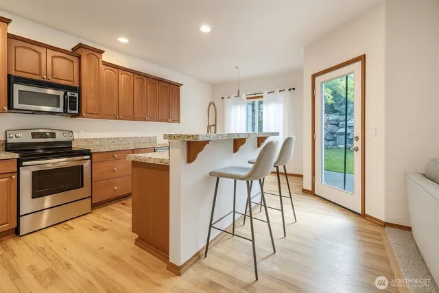 a kitchen with stainless steel appliances granite countertop a sink stove and wooden floor