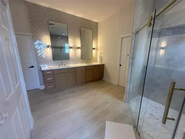 a large bathroom with a glass door shower sink and mirror