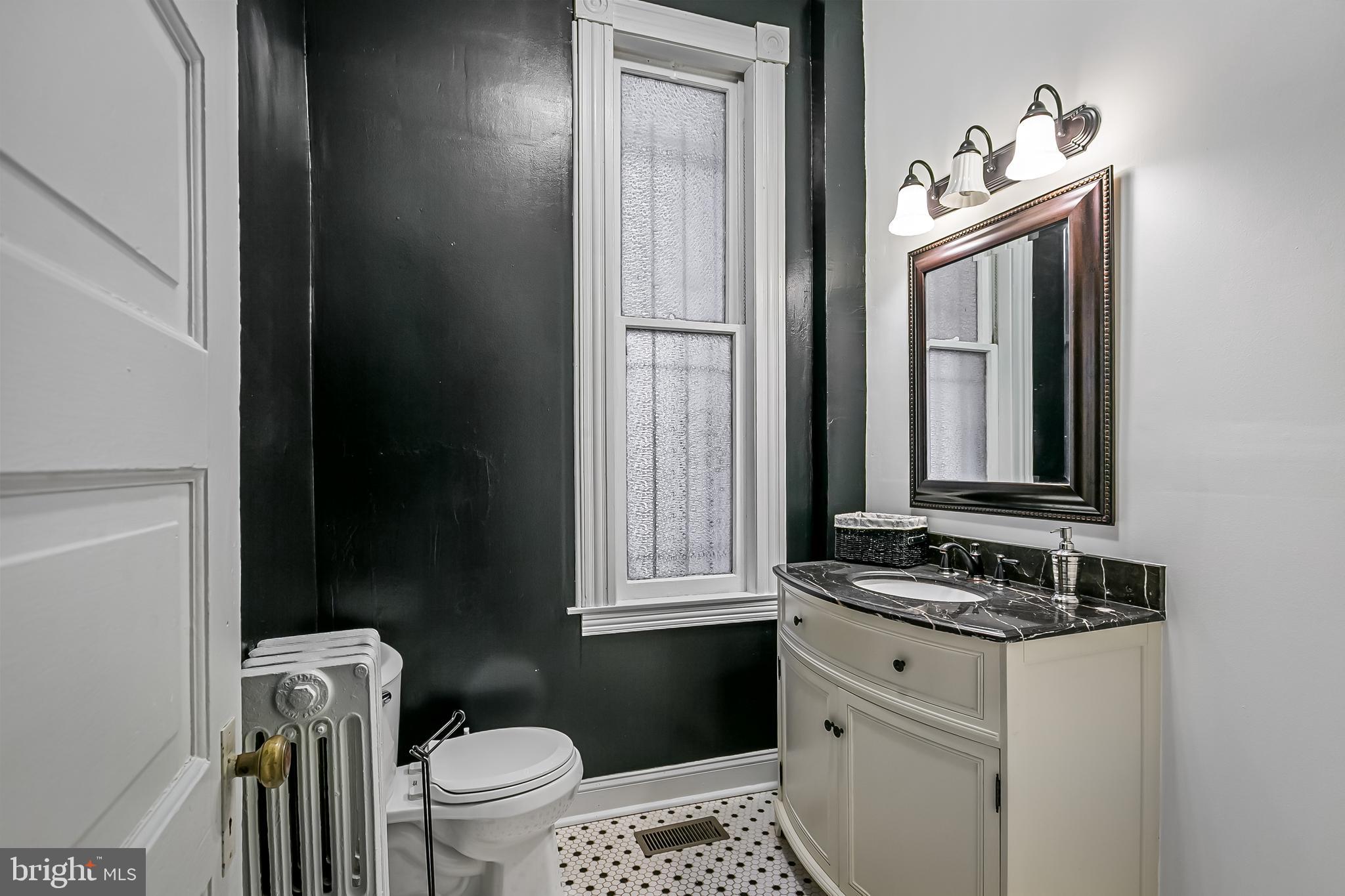 2243 Eutaw Place Baltimore, MD 21217 - Photo 30 of 54 a bathroom with a granite countertop sink toilet and mirror
