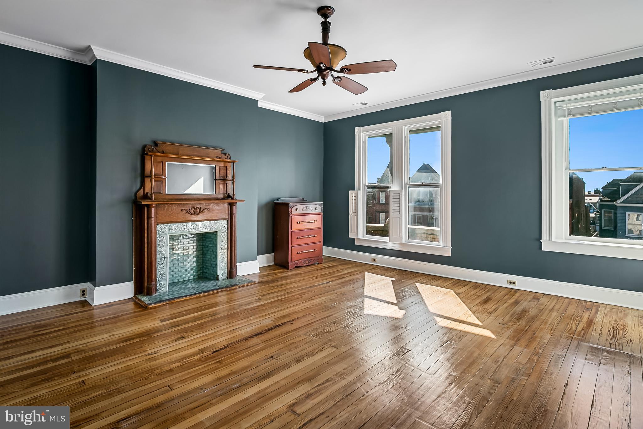 2243 Eutaw Place Baltimore, MD 21217 - Photo 41 of 54 a view of an empty room with wooden floor fireplace and a window
