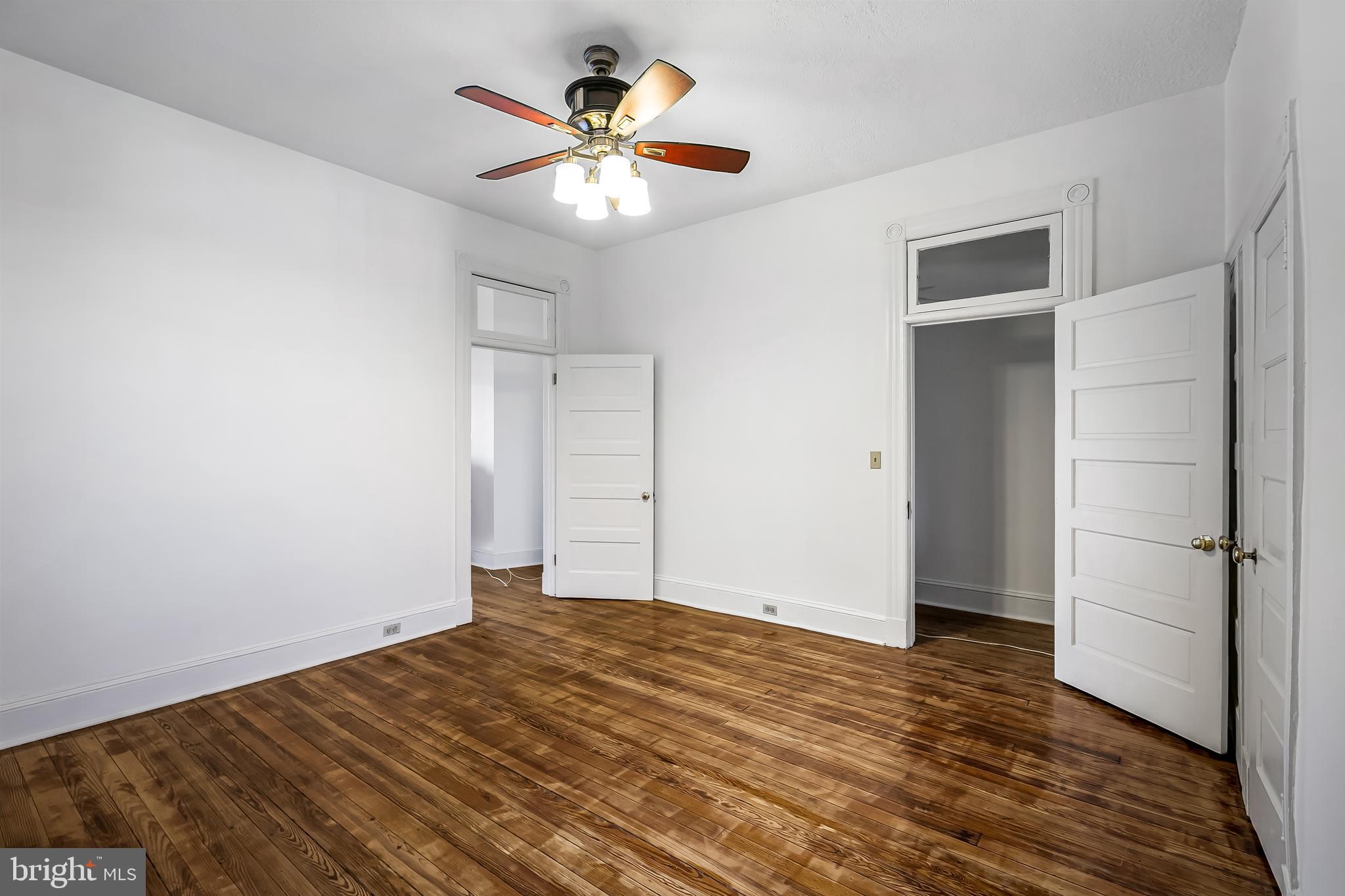 2243 Eutaw Place Baltimore, MD 21217 - Photo 45 of 54 an empty room with wooden floor and a ceiling fan