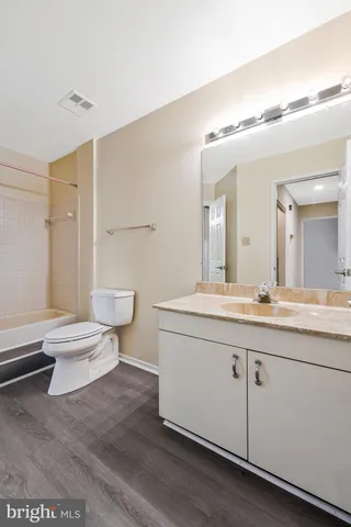 a spacious bathroom with a granite countertop sink a toilet and a mirror