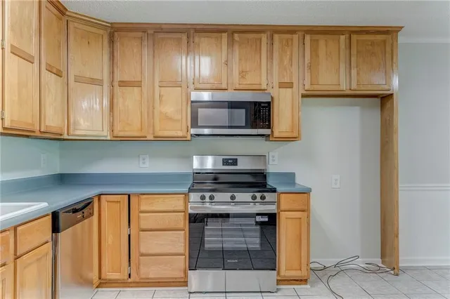 a kitchen with granite countertop wooden cabinets and a stove top oven