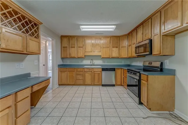 a kitchen with stainless steel appliances granite countertop a sink counter space cabinets and a stove top oven