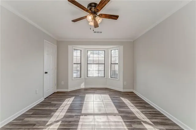 a view of a room with a ceiling fan and window