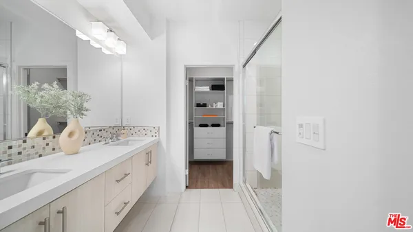 a bathroom with a sink mirror and a shower