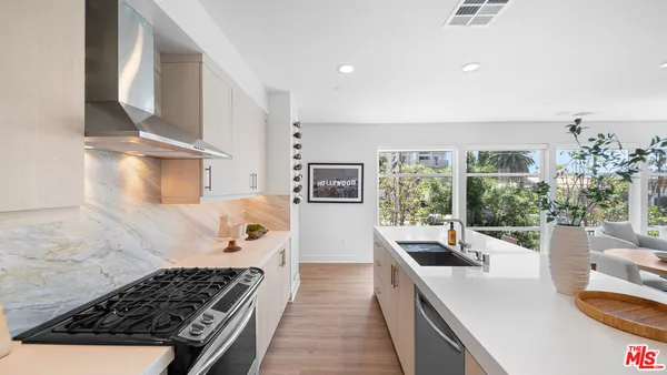 a kitchen with stainless steel appliances granite countertop a sink stove and cabinets