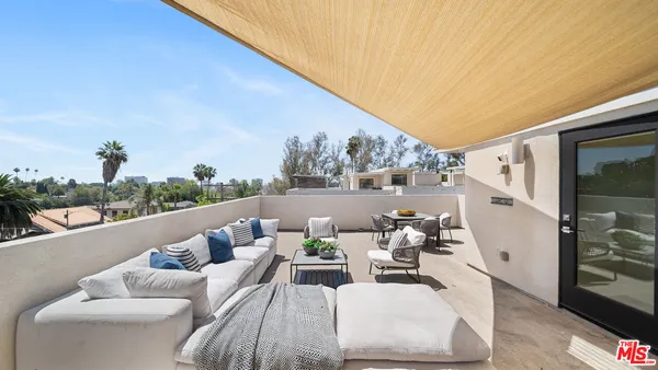 a view of a roof deck with couches and potted plants