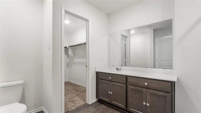 a bathroom with a granite countertop sink a toilet and a mirror