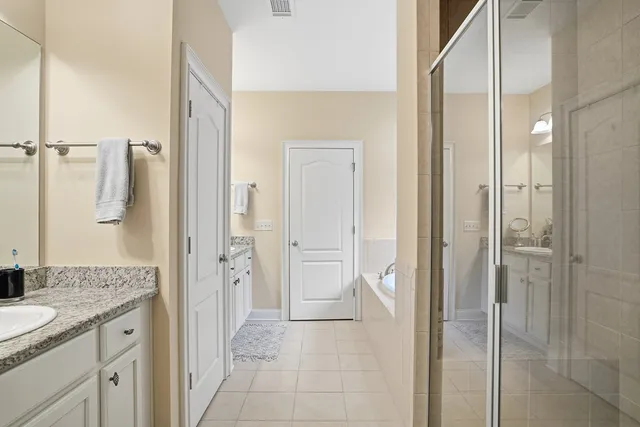 a bathroom with a granite countertop sink a mirror a shower and a glass door