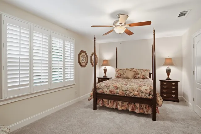 a bedroom with a bed a chandelier and a window