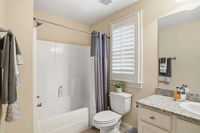 a bathroom with a granite countertop sink toilet and shower