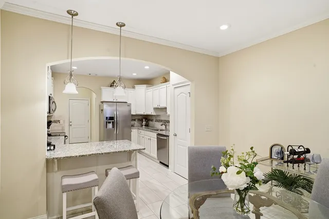 a kitchen with refrigerator and chairs