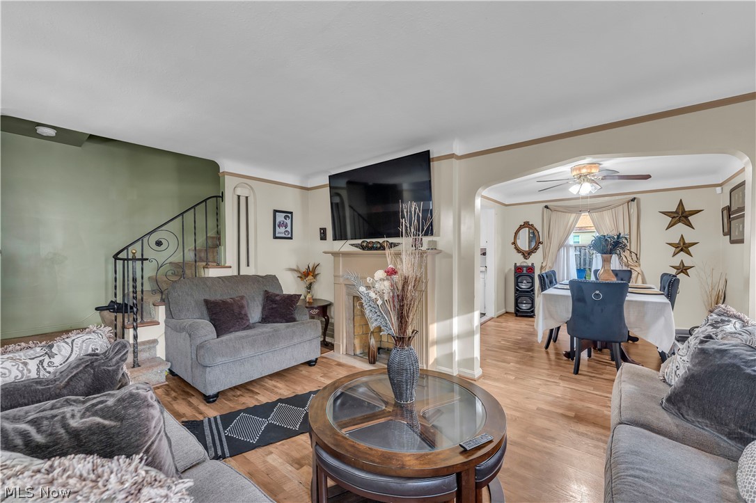 3962 Grosvenor Road South Euclid, OH 44118 - Photo 6 of 27 Living area featuring wood-finish flooring, a fireplace with a mantel, and a staircase with an ornamental wrought-iron railing