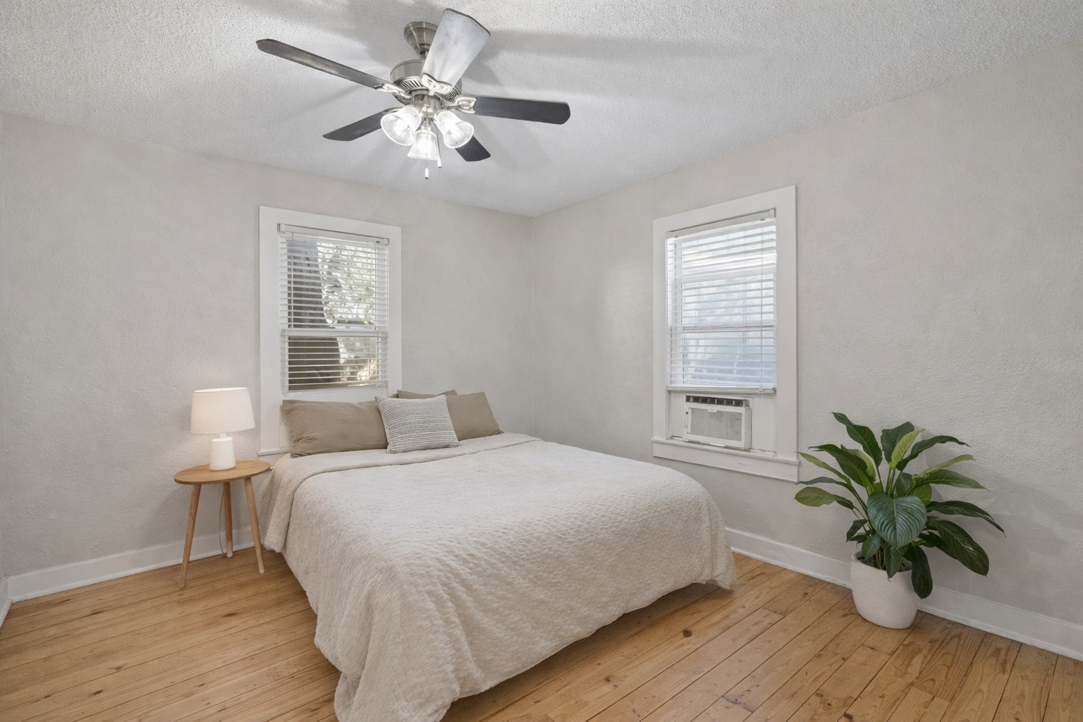 1202 East 29th Street, Unit A Austin, TX 78722 - Photo 13 of 22 Bedroom featuring light wood-type flooring, a textured ceiling, a ceiling fan, and cooling unit