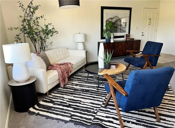 a living room with furniture a lamp and a potted plant