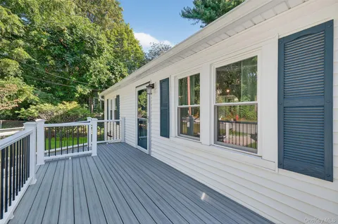 a porch with wooden floor in front of house