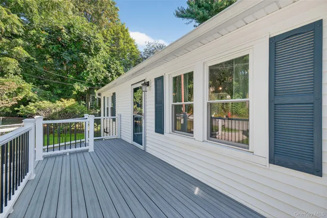 a porch with wooden floor in front of house