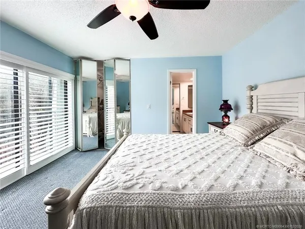 a bedroom with a large bed and dresser with mirror