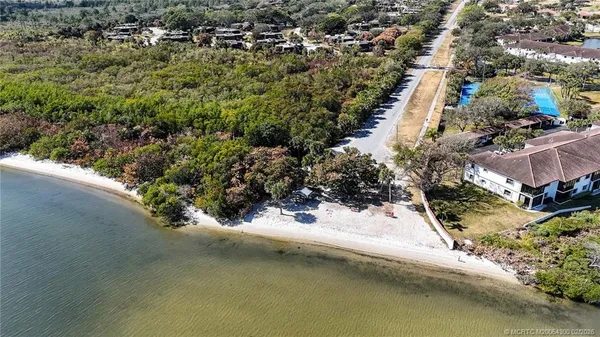 an aerial view of a house with a yard and lake view