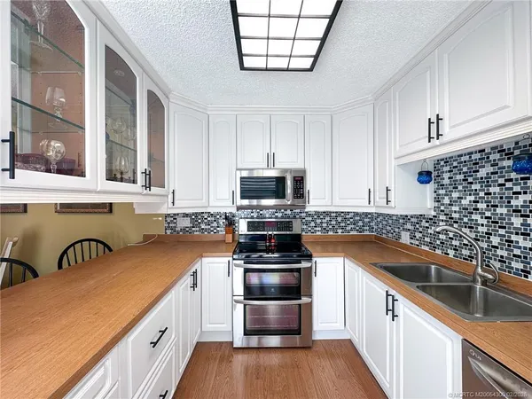 a kitchen with granite countertop a sink and steel appliances