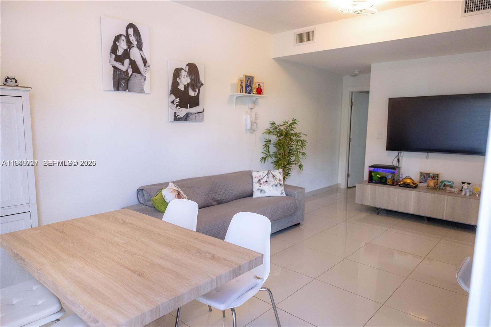 25874 Southwest 139th Path, Unit 25874 Homestead, FL 33032 - Photo 3 of 7 a bedroom with furniture and a flat screen tv