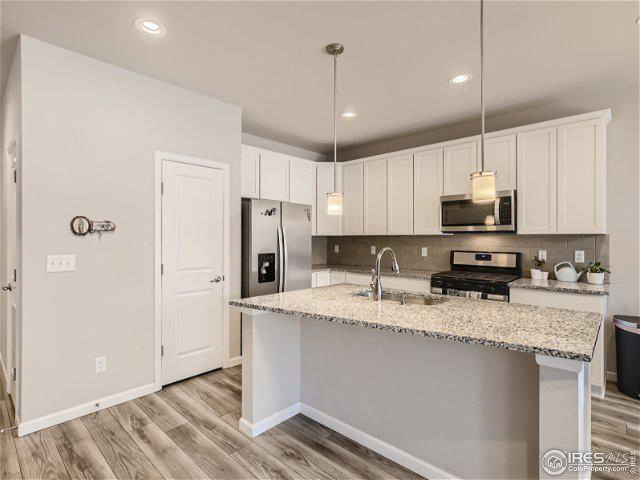 555 Ranchhand Drive Berthoud, CO 80513 - Photo 4 of 11 a kitchen with stainless steel appliances granite countertop a refrigerator a sink a stove a microwave and wooden cabinets