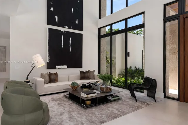 a living room with furniture a flat screen tv and a refrigerator