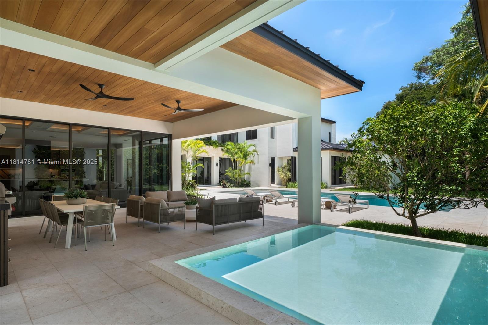 6730 Southwest 115th Street Pinecrest, FL 33156 - Photo 49 of 77 a view of a patio with couches table and chairs and potted plants