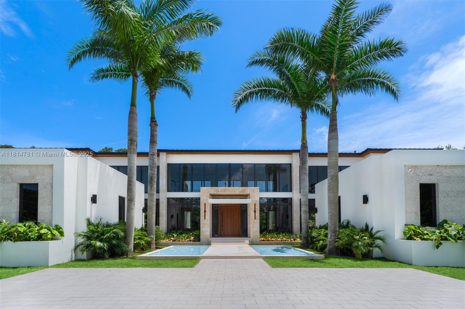 6730 Southwest 115th Street Pinecrest, FL 33156 - Photo 8 of 77 a front view of a house with yard and garage