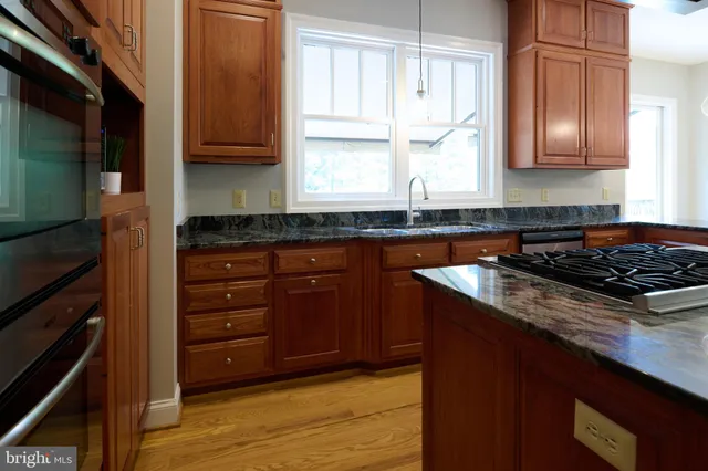 a kitchen with granite countertop white cabinets and sink